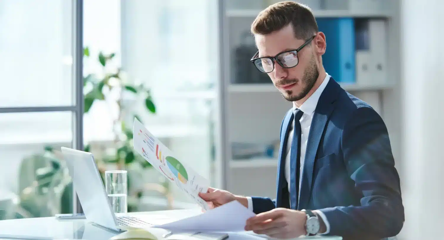 Man with Glasses Analyzing Charts